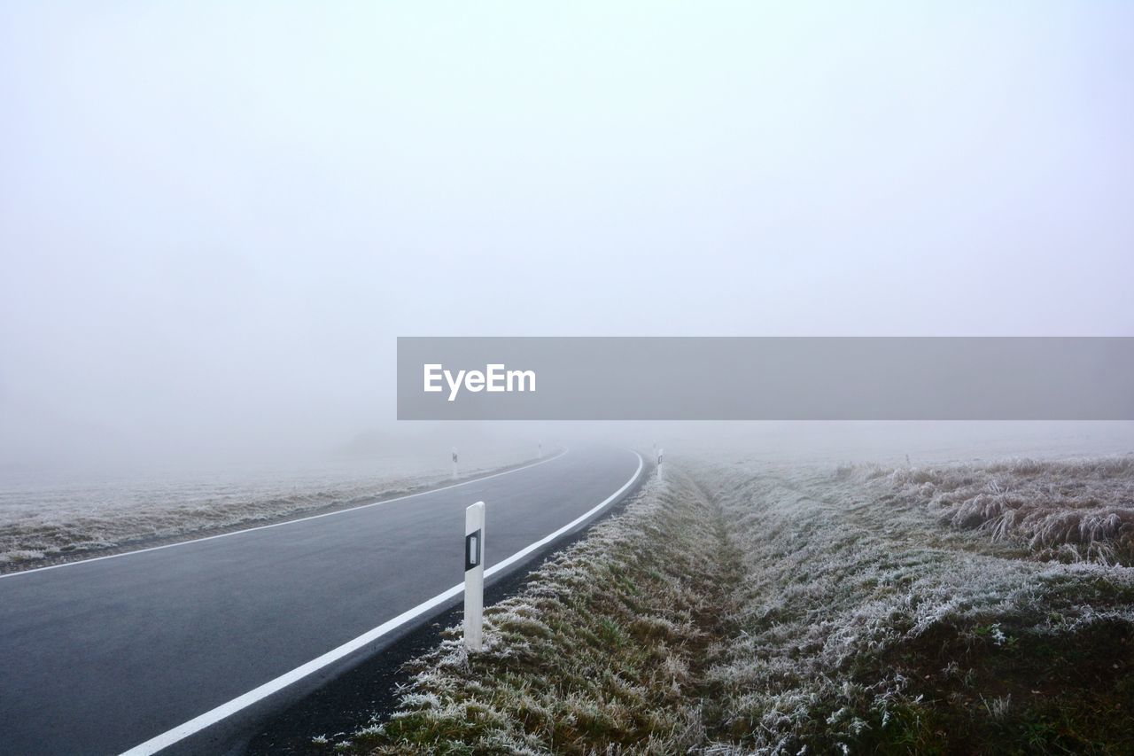 Scenic view of road against sky during foggy weather