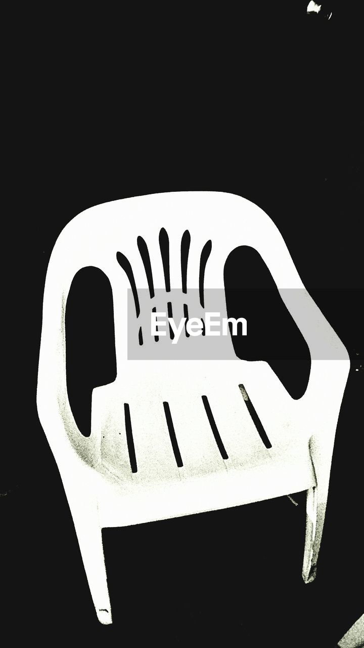 High angle view of white chair against black background