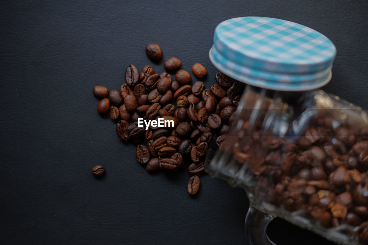 Coffee beans scattered from the glass isolated on black background