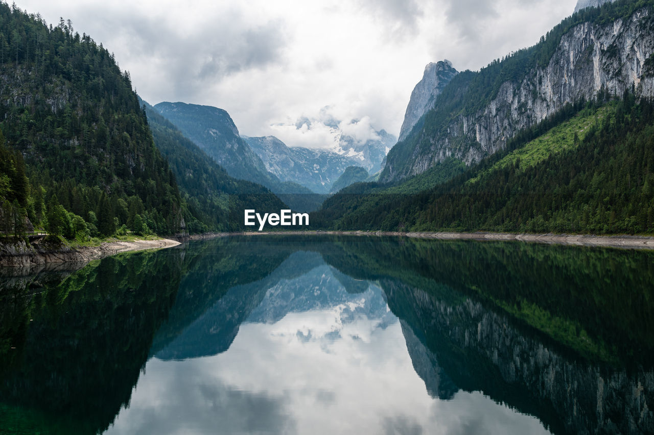 SCENIC VIEW OF MOUNTAINS BY LAKE AGAINST SKY