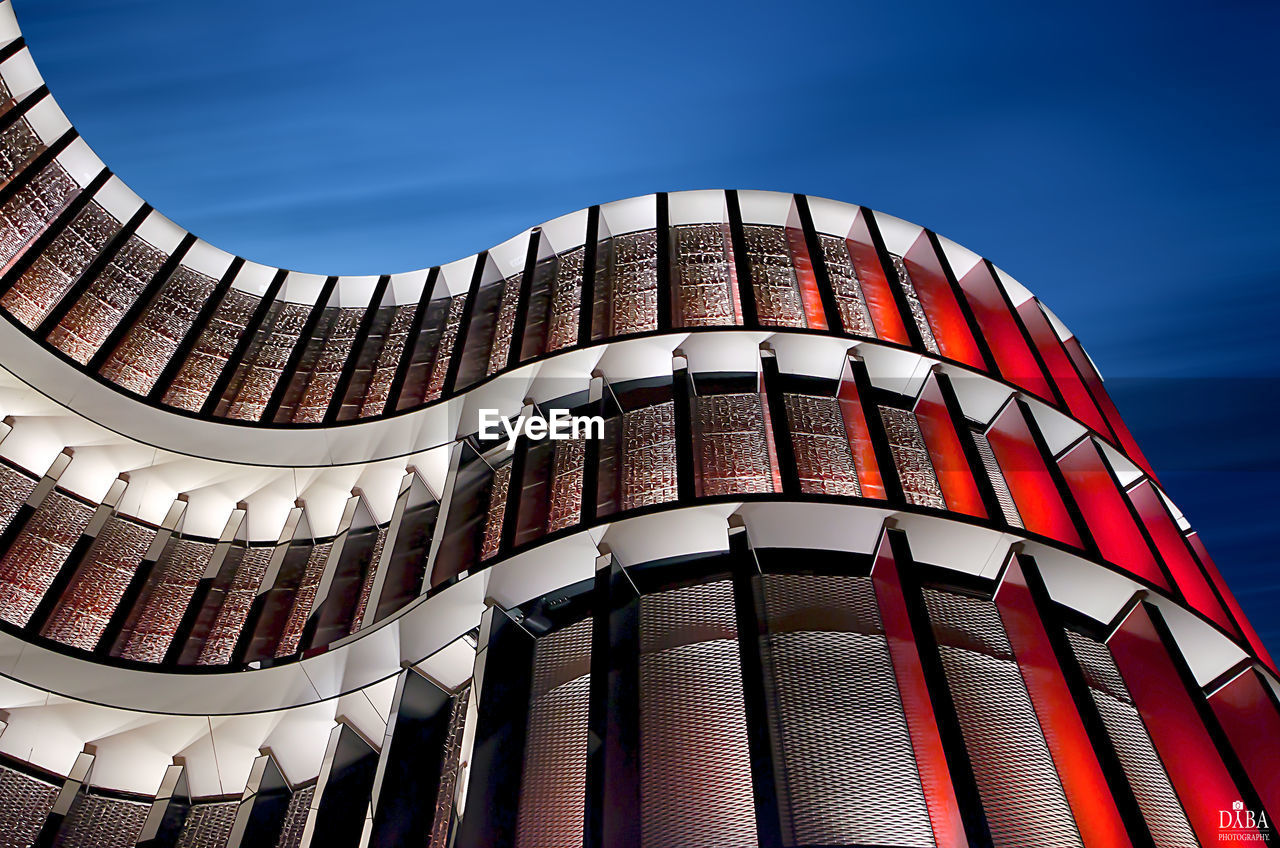 Low angle view of modern building against blue sky