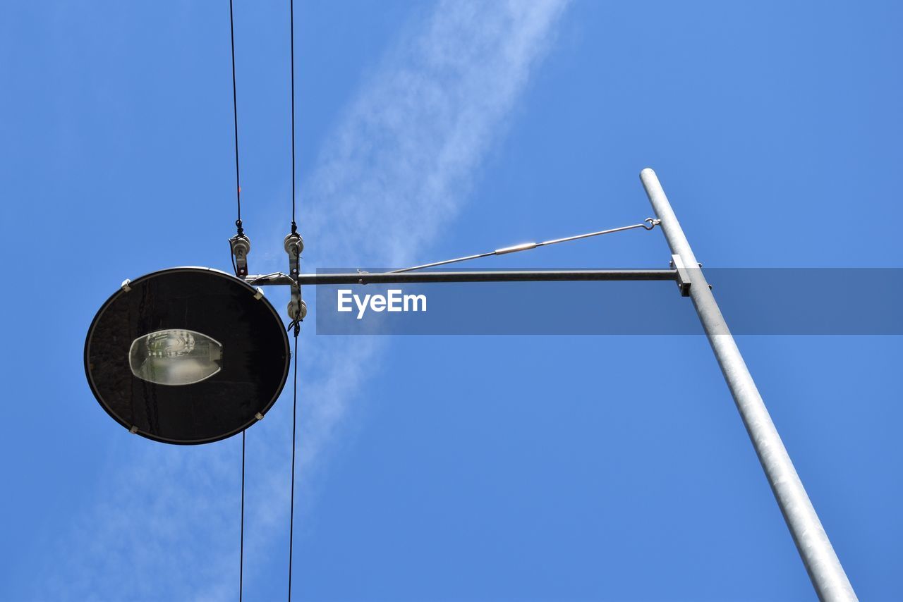 Low angle view of street light and cables against blue sky