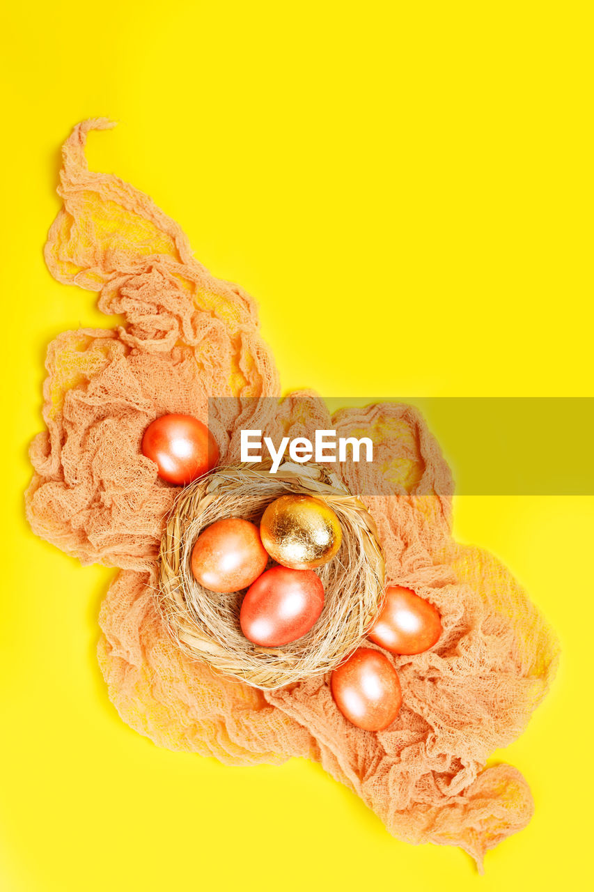 HIGH ANGLE VIEW OF EGGS IN YELLOW BACKGROUND