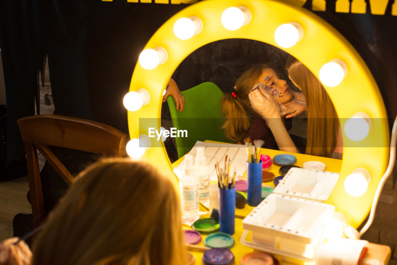 HIGH ANGLE VIEW OF PEOPLE ON ILLUMINATED TABLE