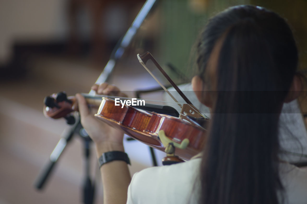 Rear view of woman playing violin