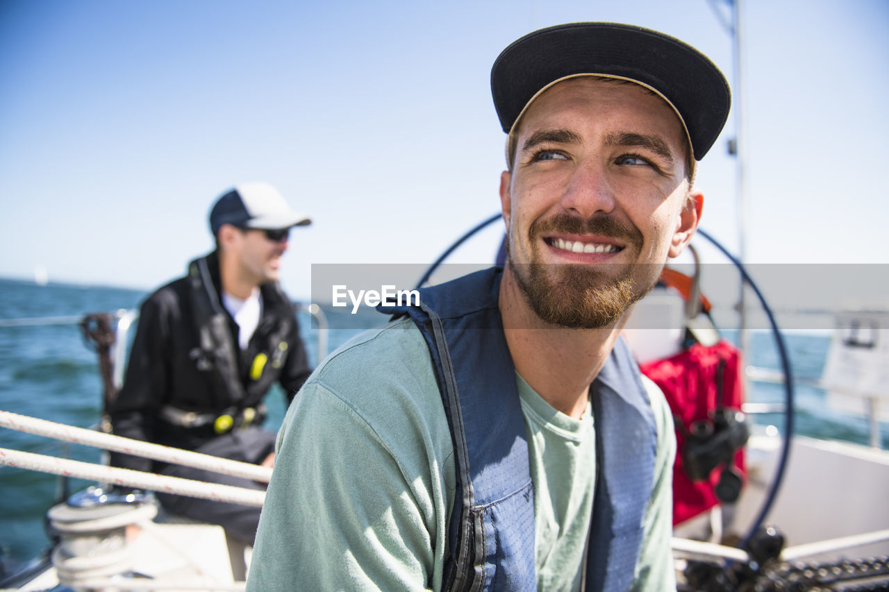 Man smiling during a family sail on sunny summer day