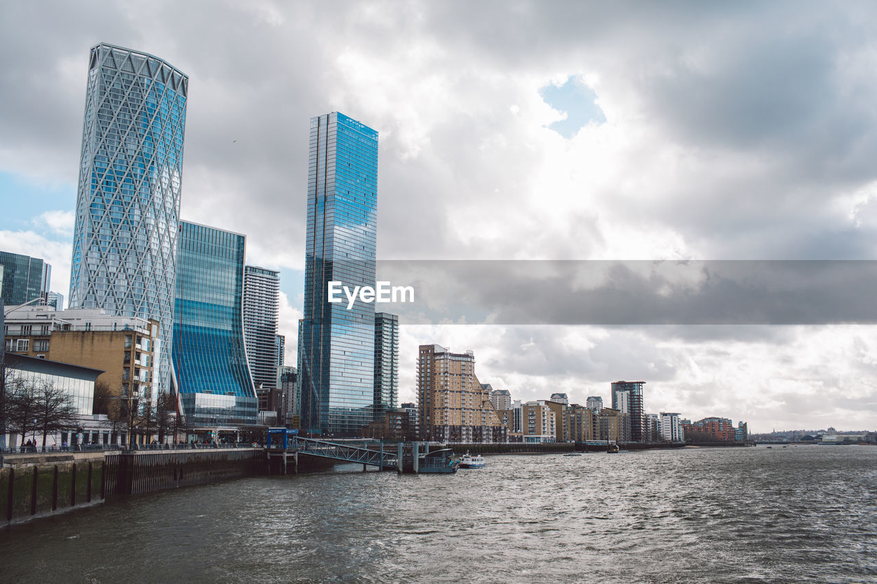 modern buildings in city against cloudy sky