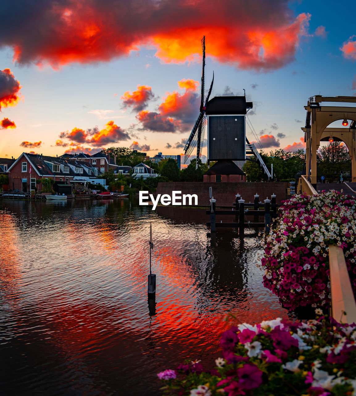 SCENIC VIEW OF LAKE BY BUILDING AGAINST SKY DURING SUNSET