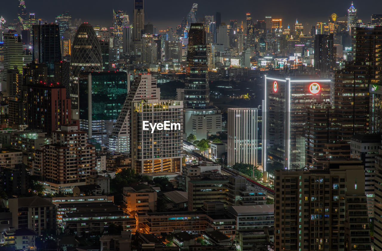 HIGH ANGLE VIEW OF ILLUMINATED BUILDINGS AT NIGHT