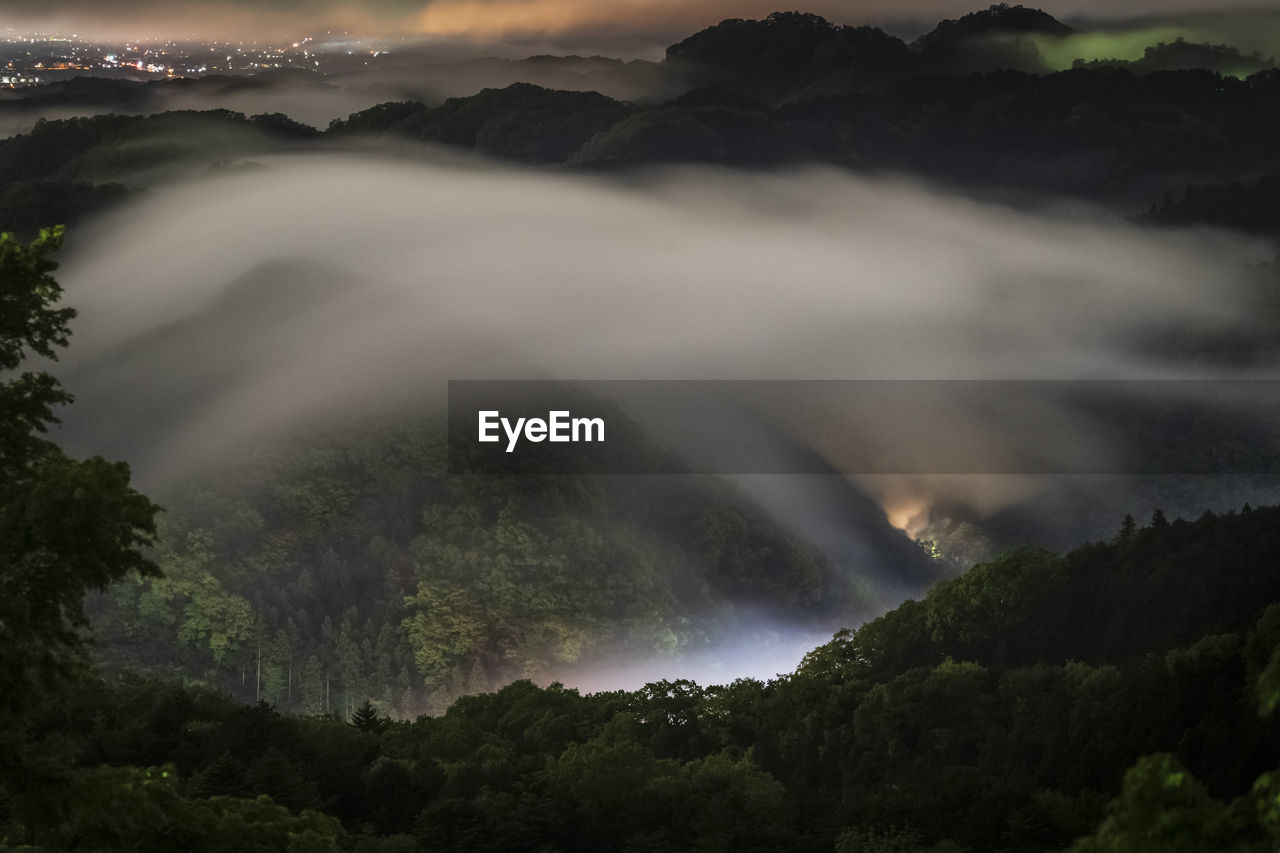 View of mountains during foggy weather at night