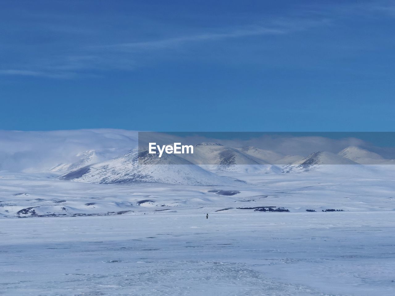 Scenic view of snowcapped mountains against blue sky