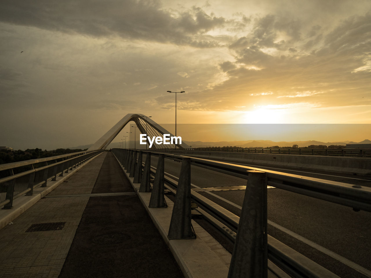 View of suspension bridge against cloudy sky