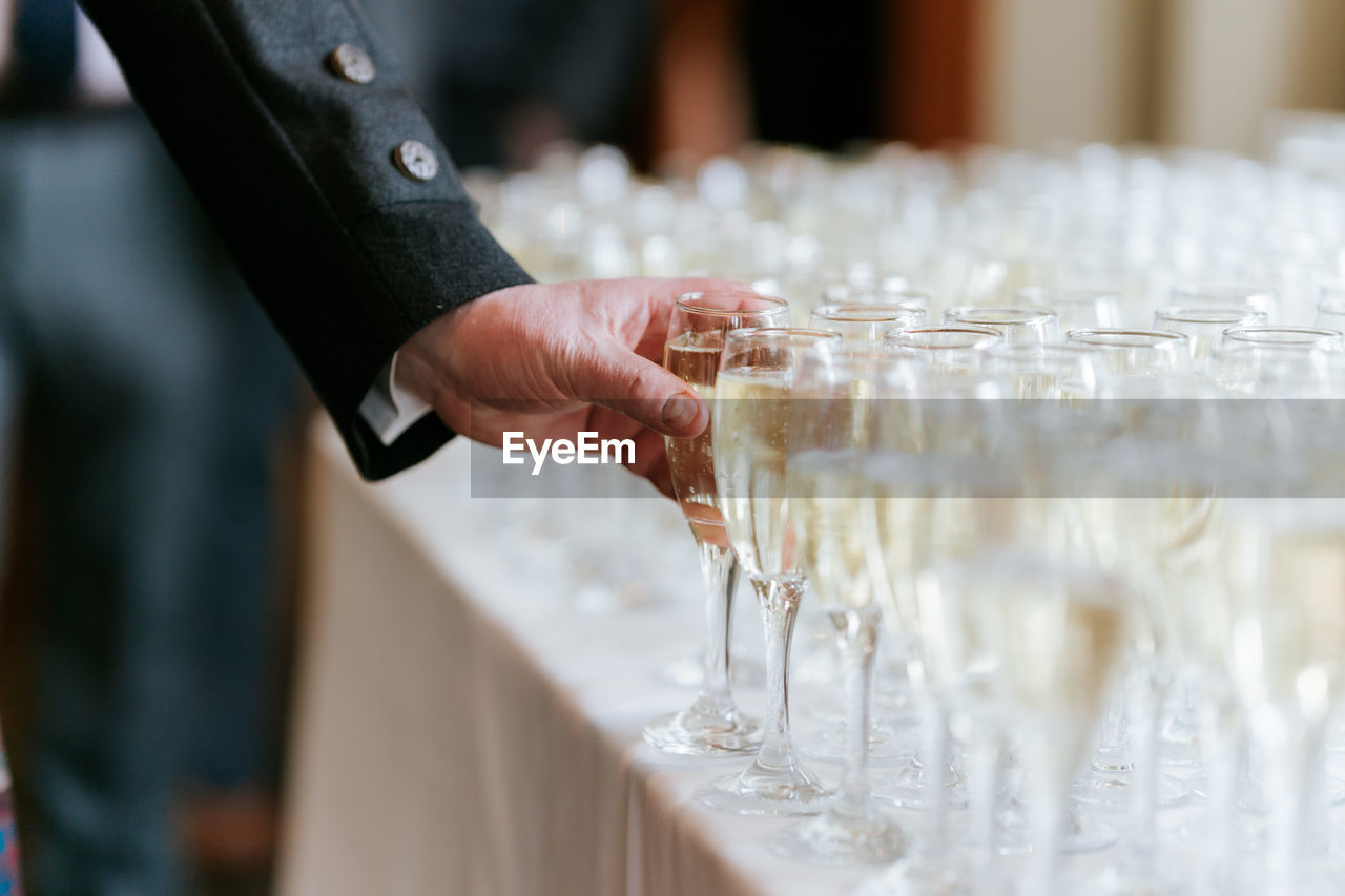 Midsection of man holding glass wedding reception