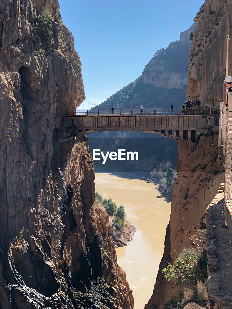 Arch bridge over rock formation against sky