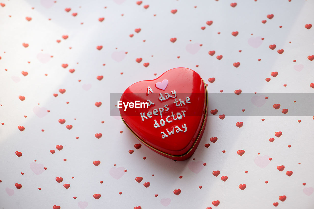 HIGH ANGLE VIEW OF HEART SHAPE ON RED TABLE