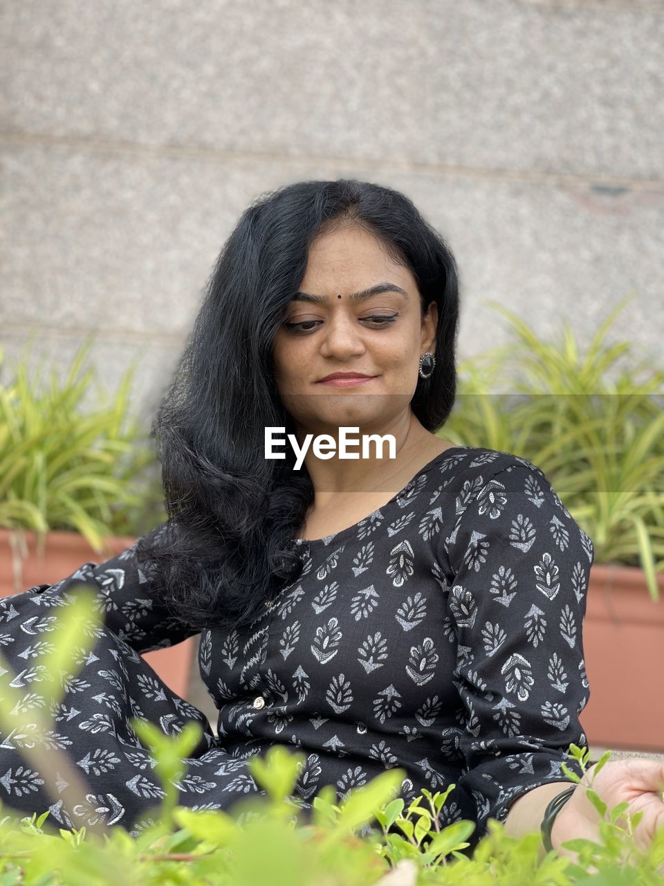 portrait of beautiful young woman sitting on field