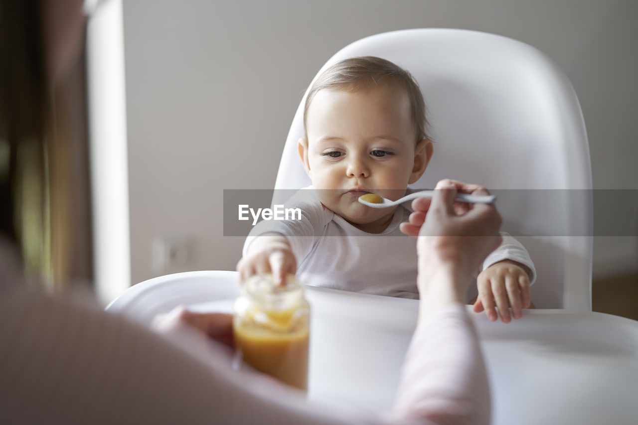 Portrait of smiling young woman having food at home