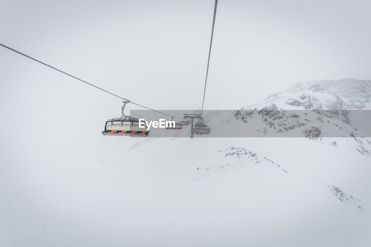 Ski lifts against clear sky during winter