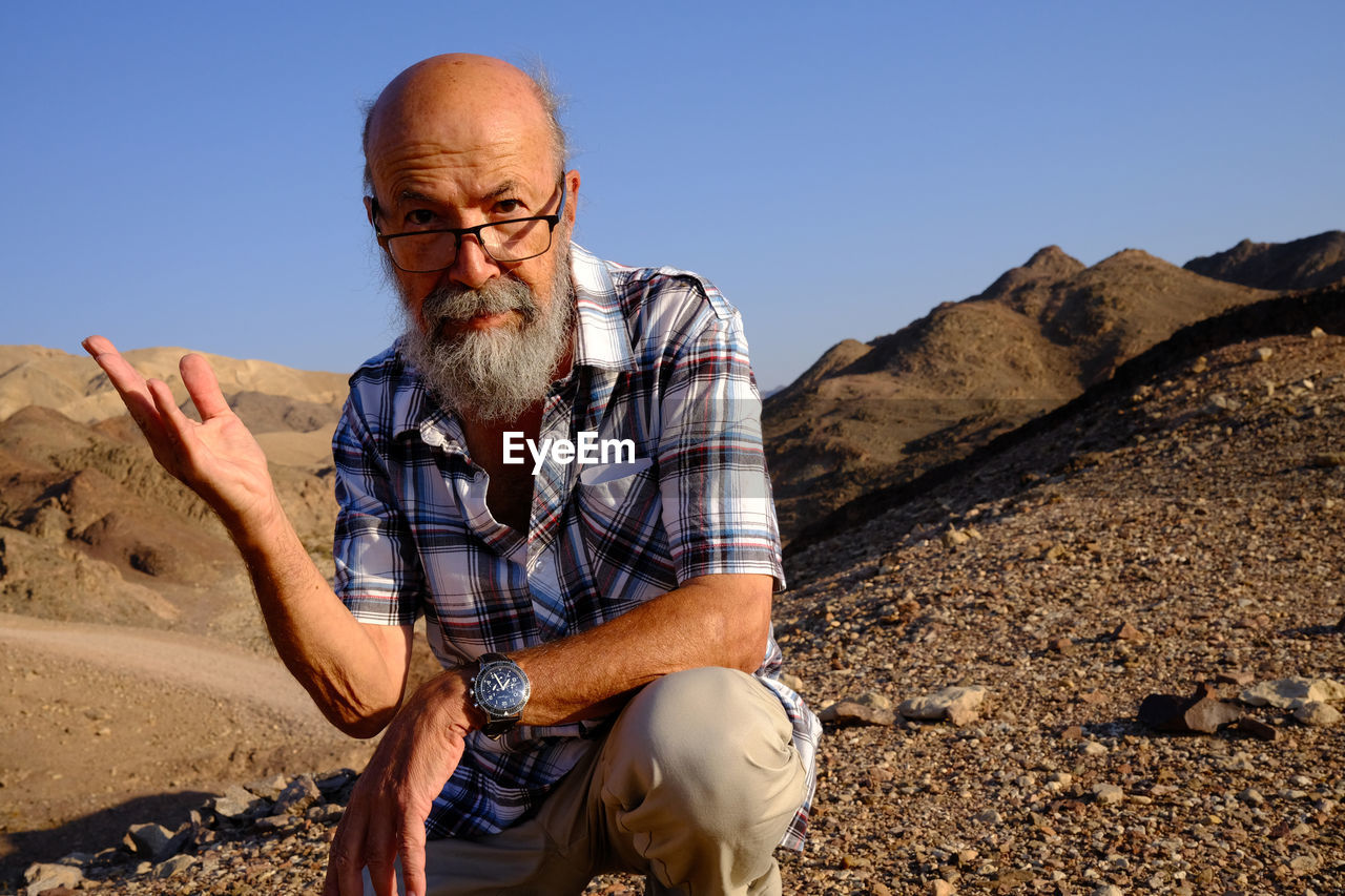 Senior bearded man looking away in the desert 