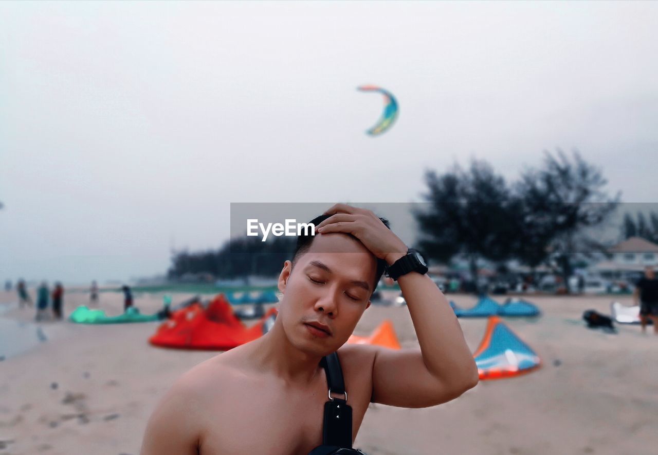 Young man on beach against sky