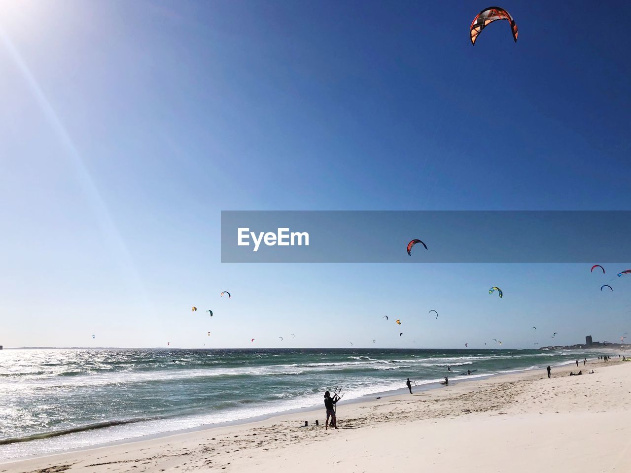 PEOPLE AT BEACH AGAINST SKY