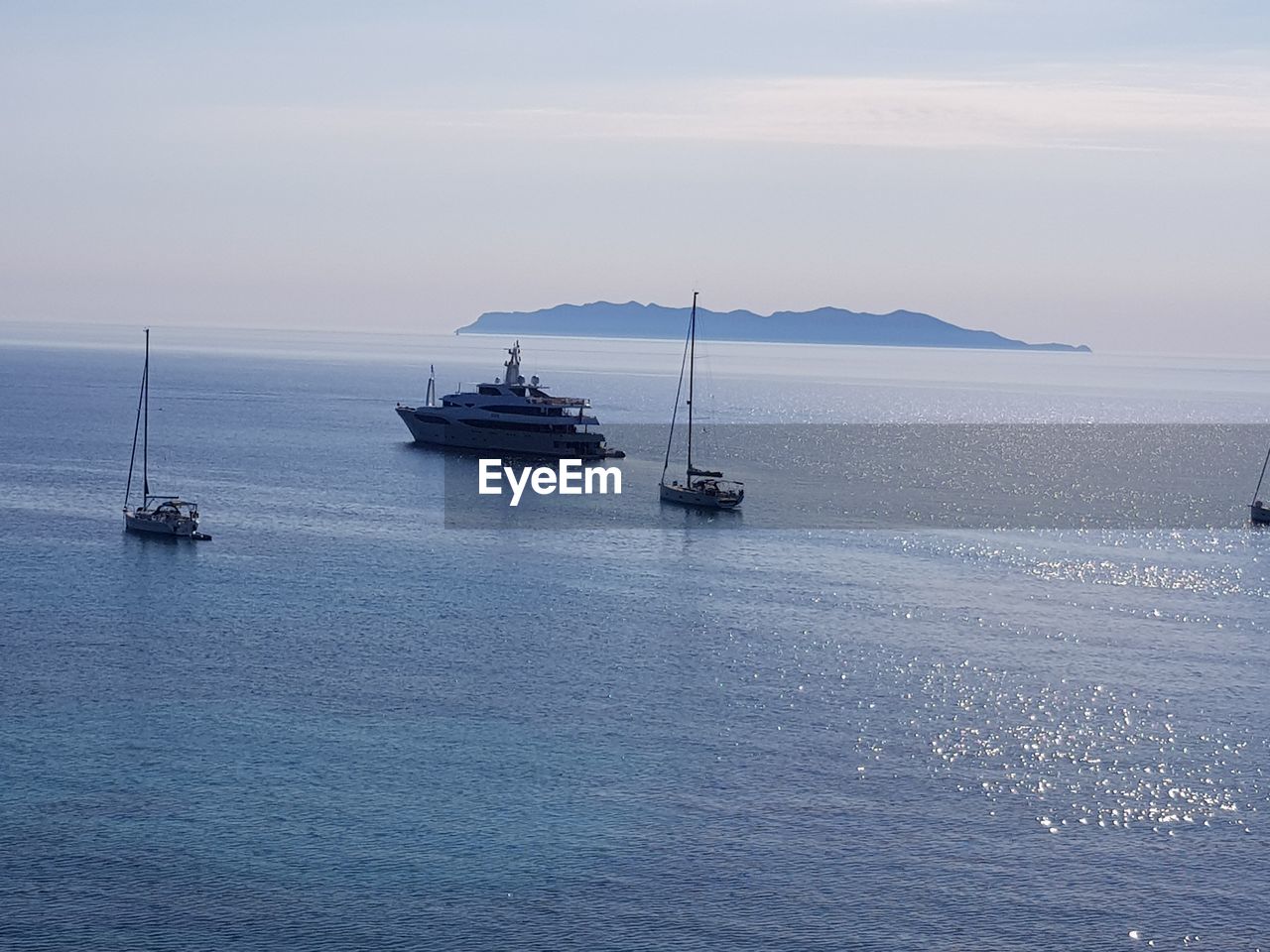 BOATS SAILING IN SEA AGAINST SKY