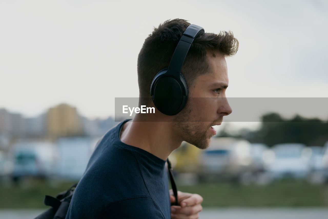 Young man with headphones on city street