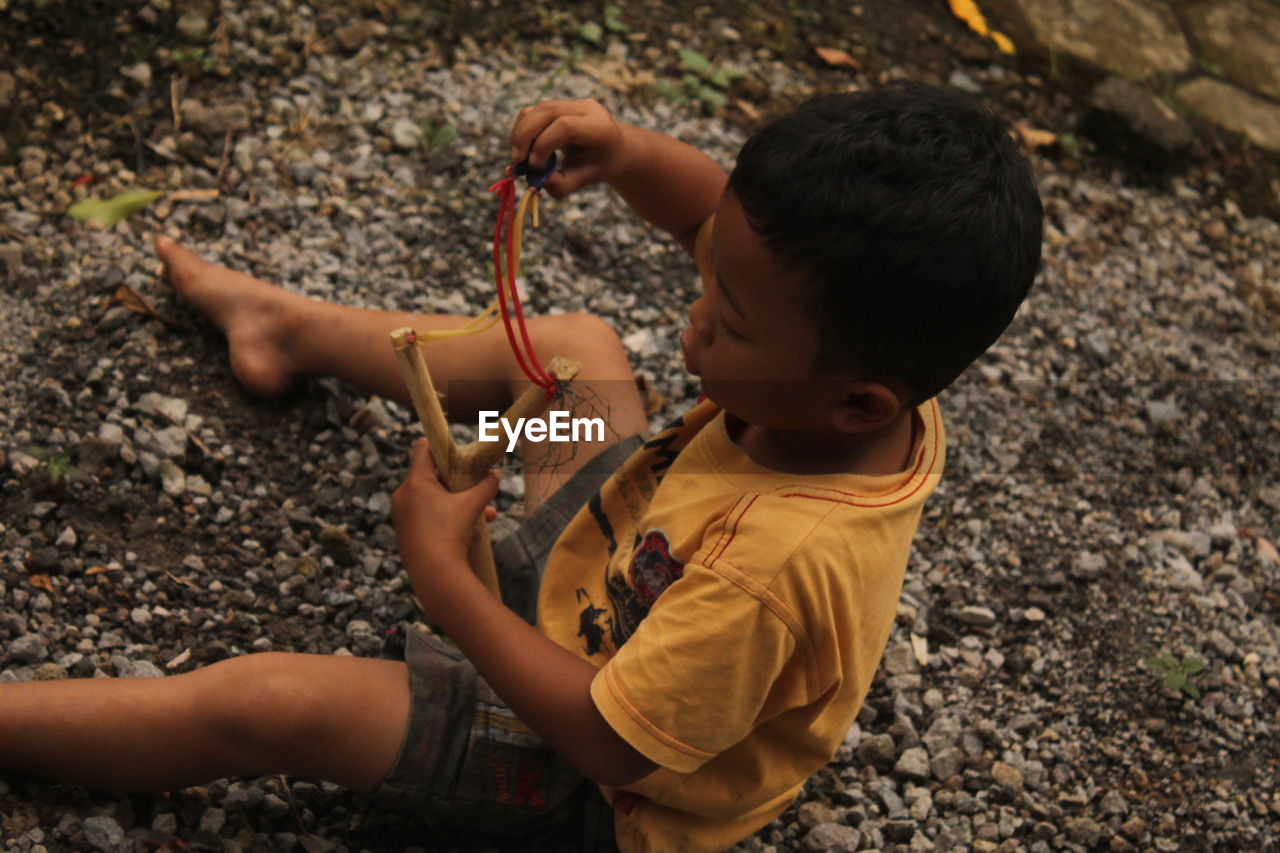 Side view of boy playing with plants