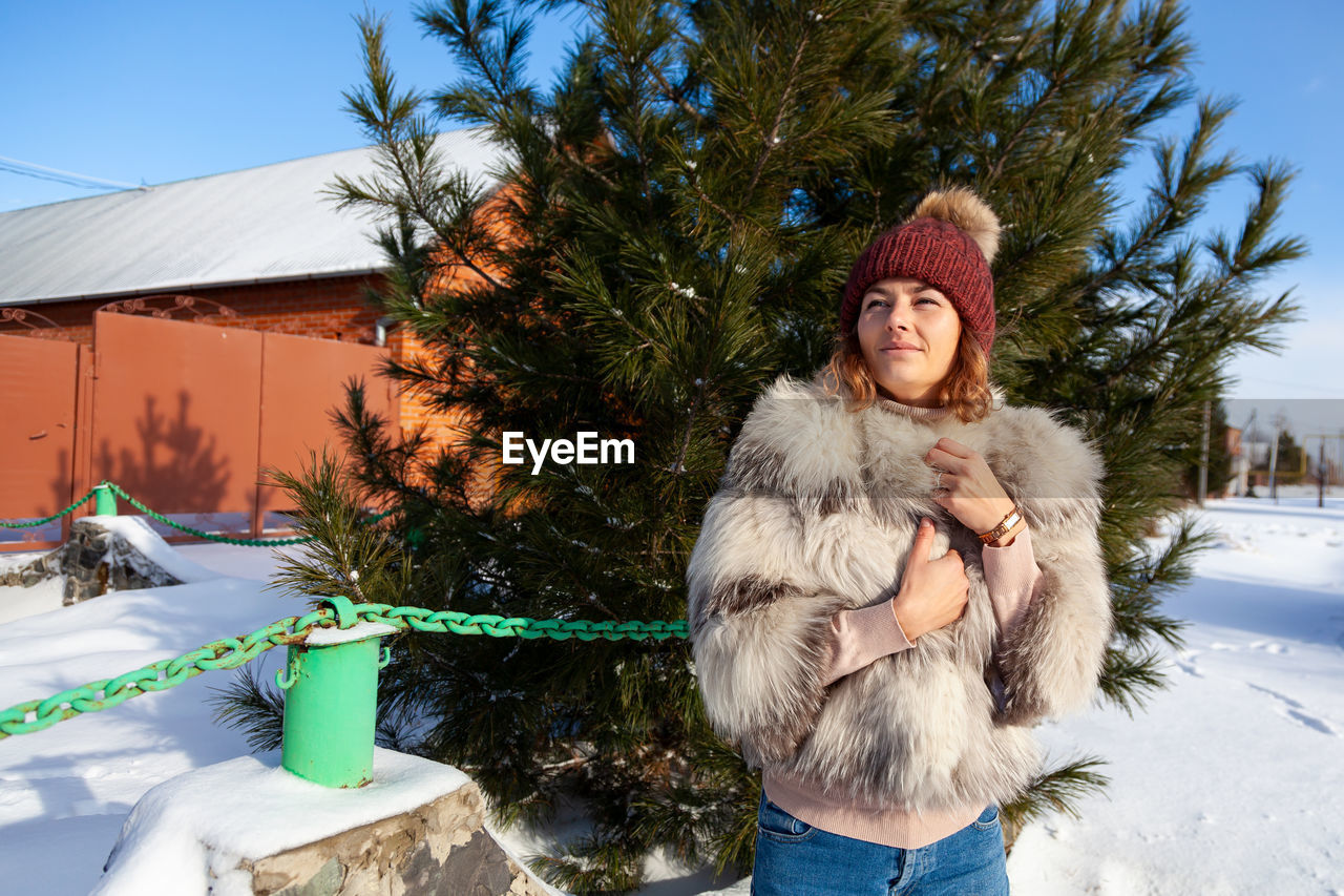 Woman wearing fur coat standing outdoors during winter