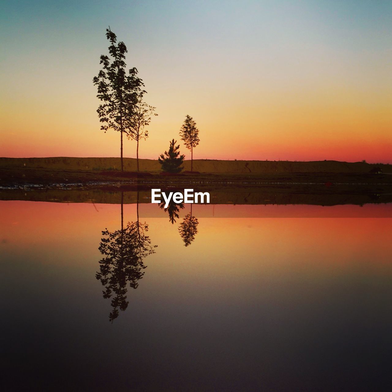 SCENIC VIEW OF LAKE AGAINST ORANGE SKY