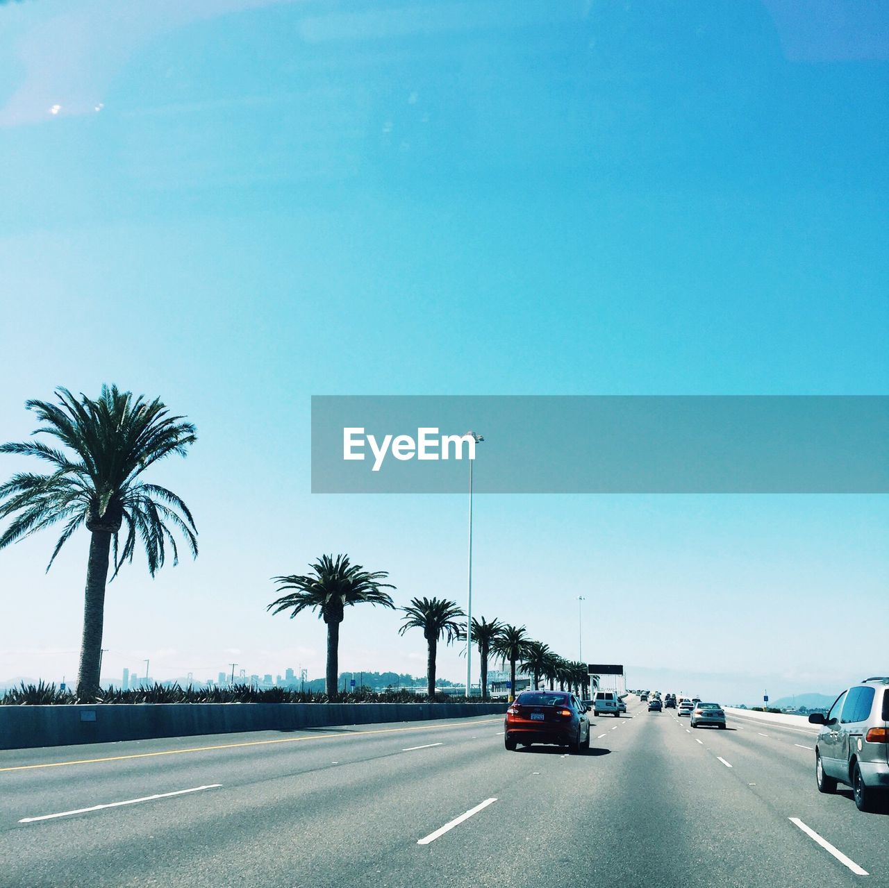 Cars on road against clear blue sky