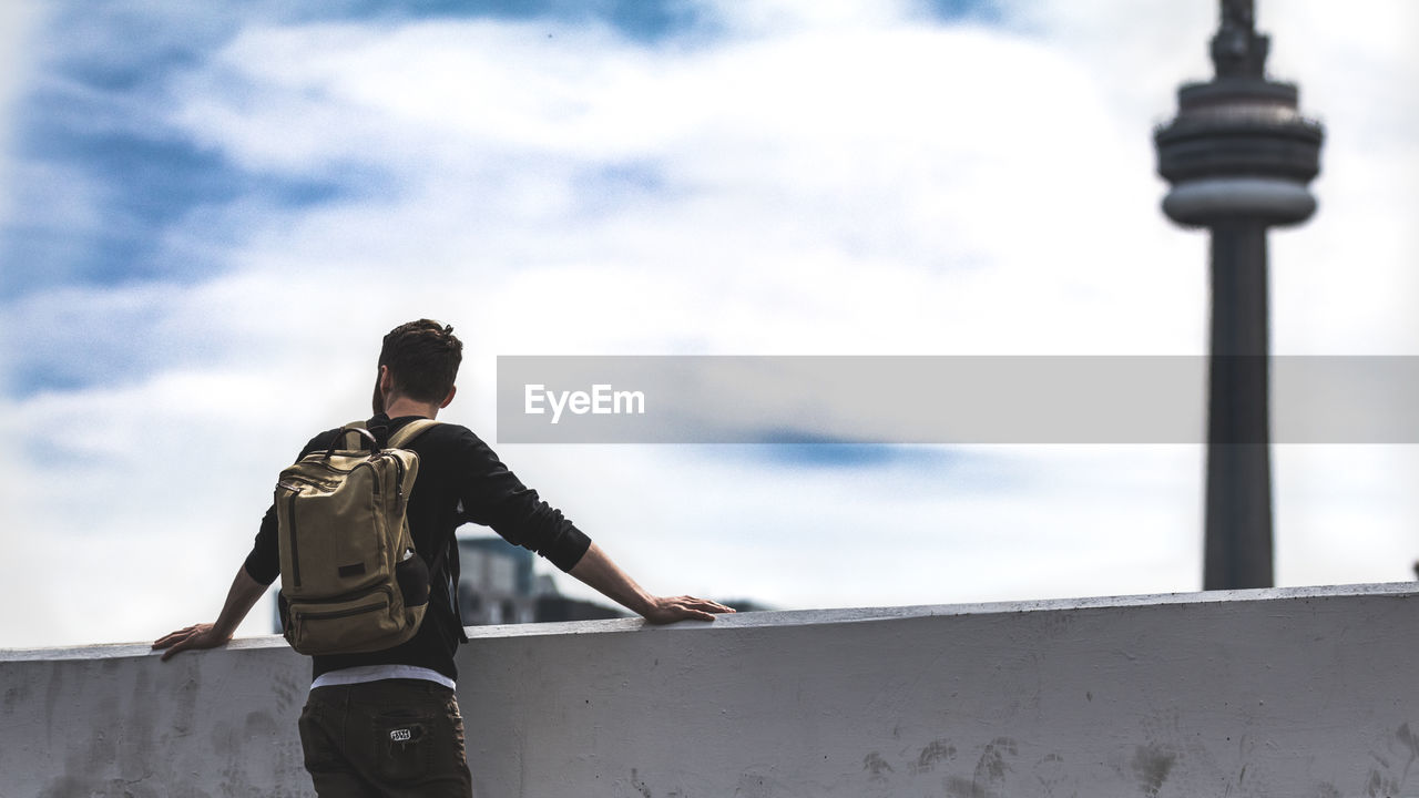 LOW ANGLE VIEW OF MAN STANDING IN FRONT OF SKY