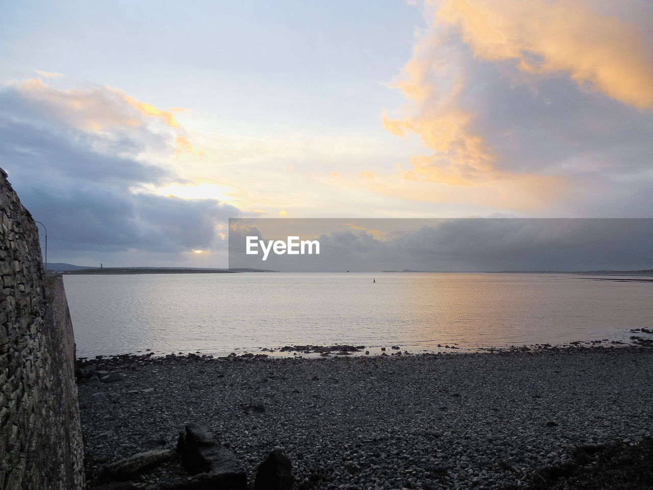 SCENIC VIEW OF BEACH AGAINST SKY DURING SUNSET