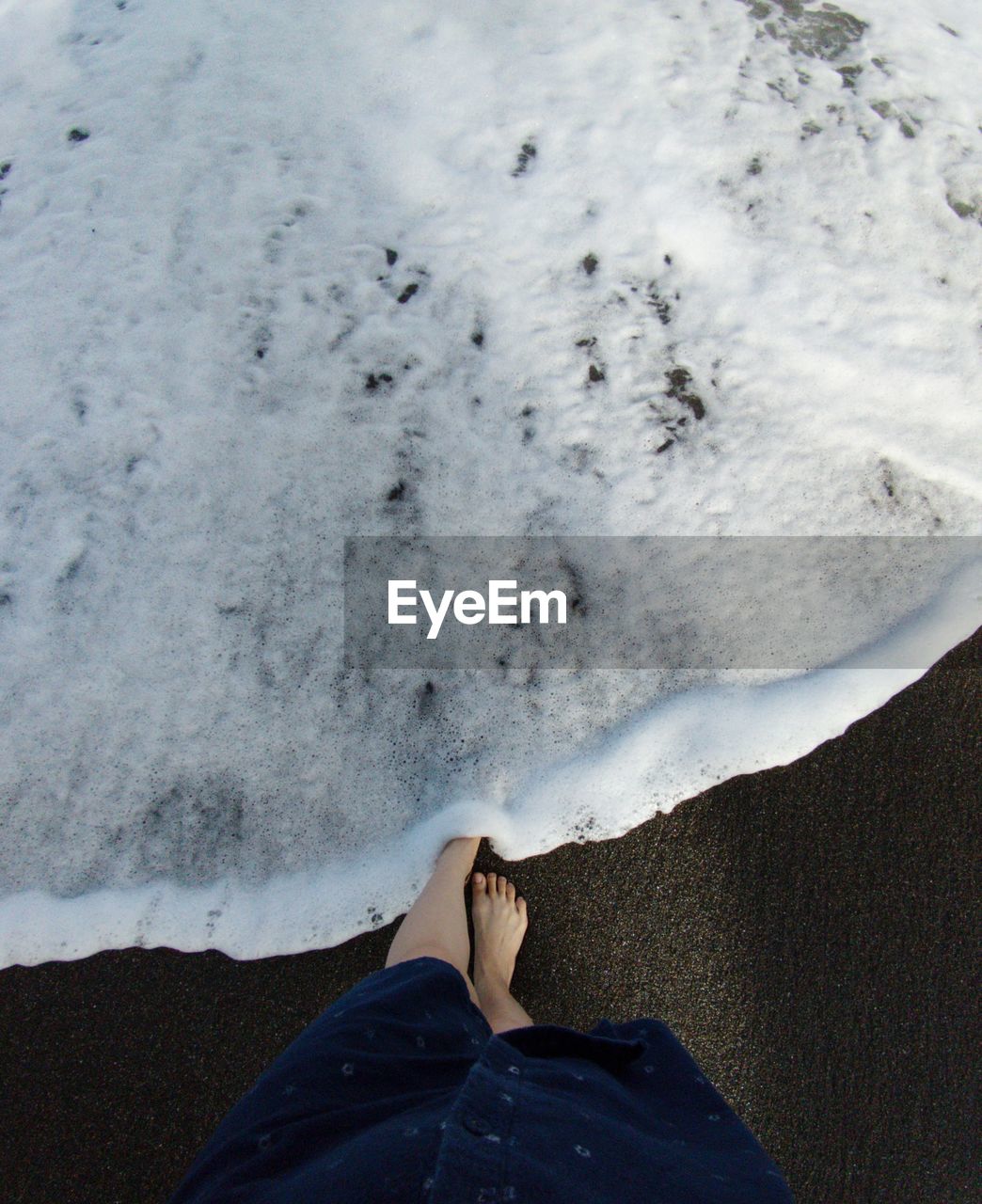 Low section of woman standing on beach