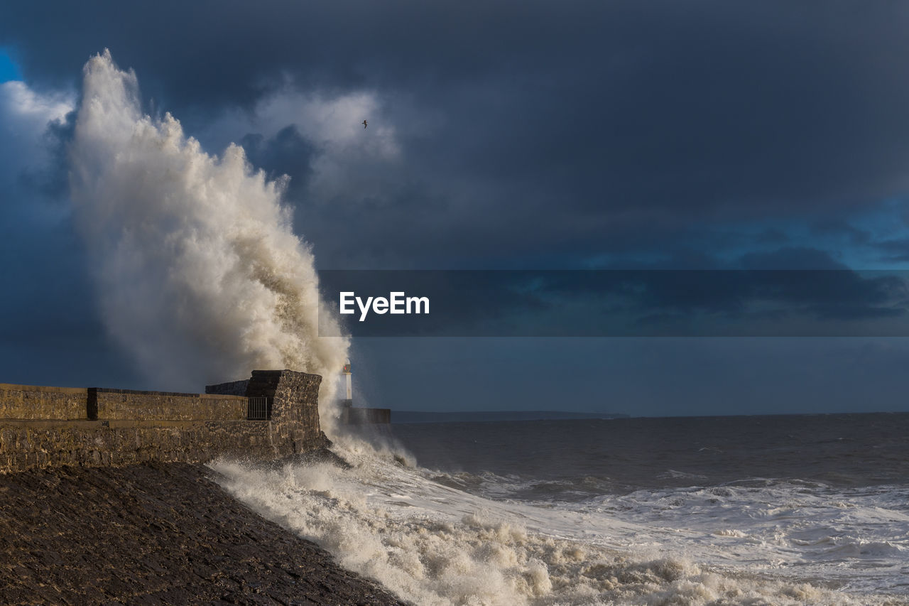 Scenic view of splashing waters in sea against sky