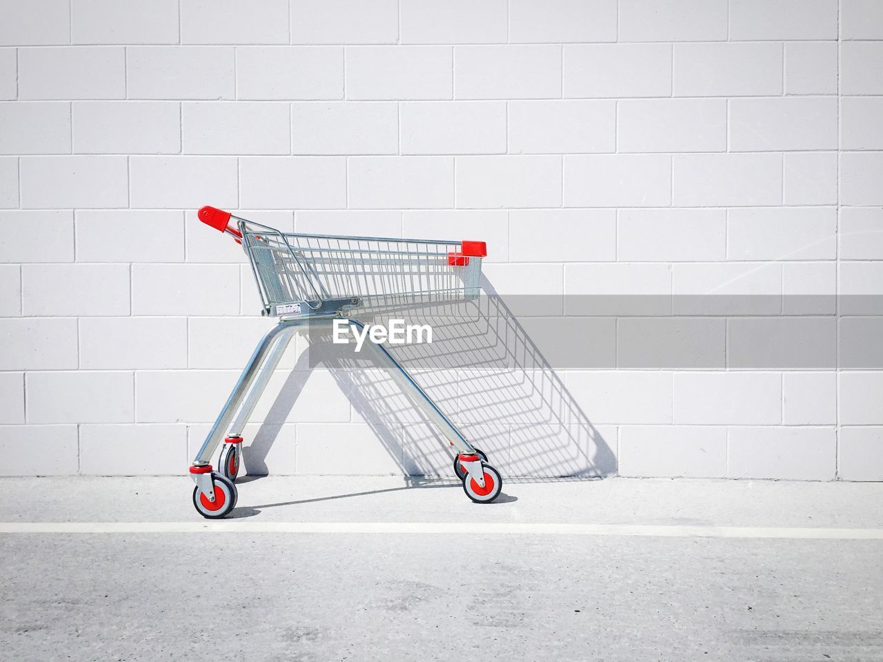 Shopping cart against white wall