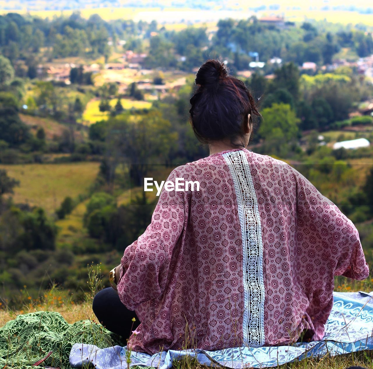 Rear view of woman sitting on hill
