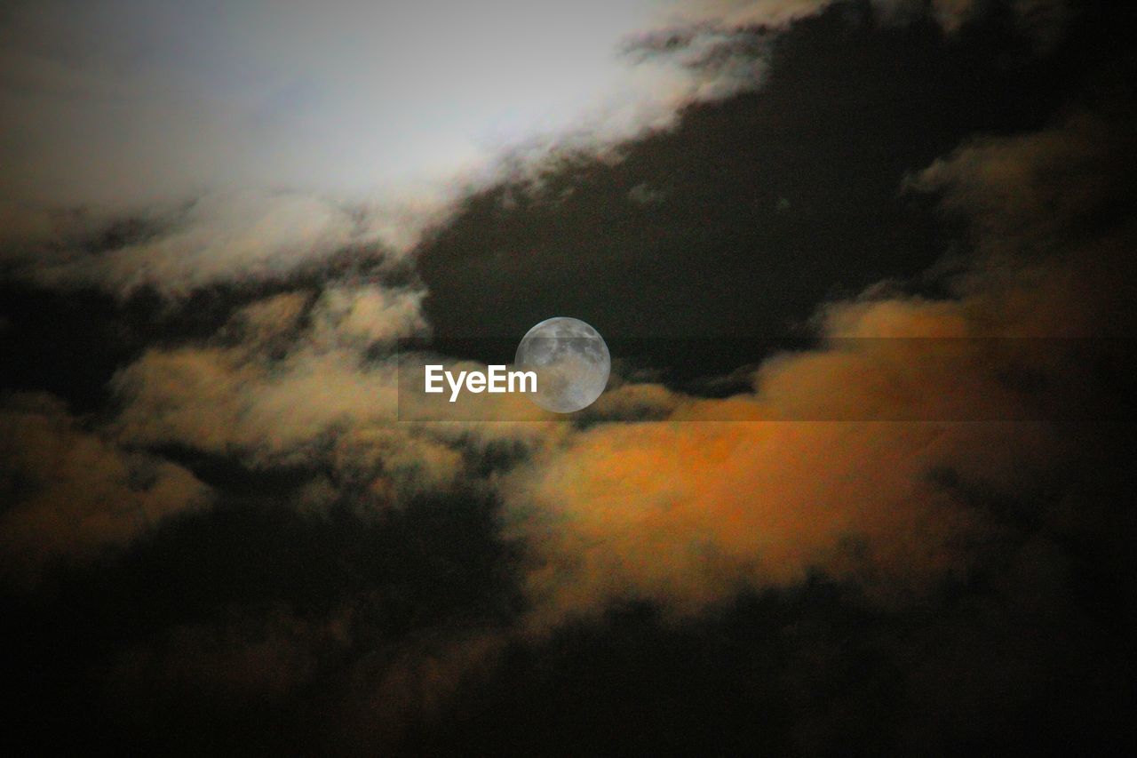 Idyllic shot of moon amidst clouds in sky