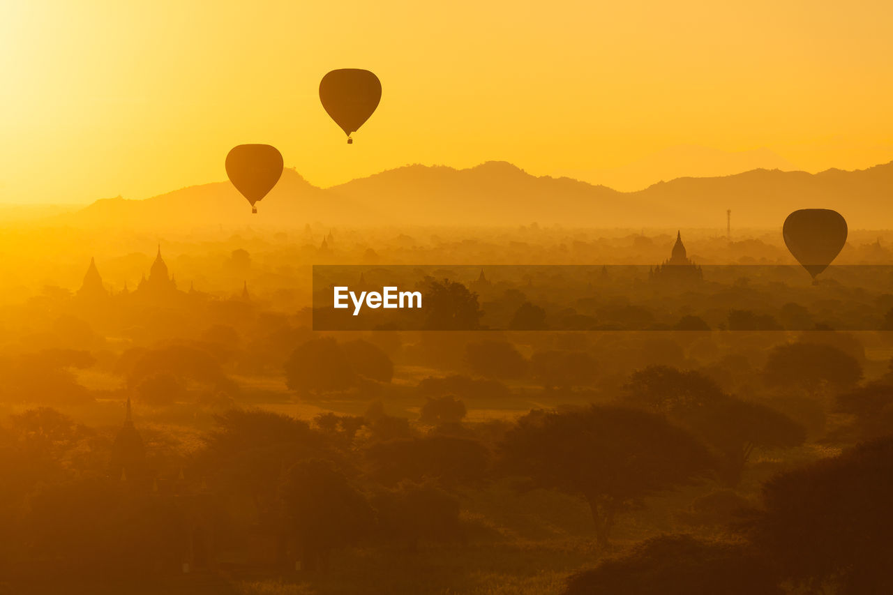 Hot air balloons flying over landscape