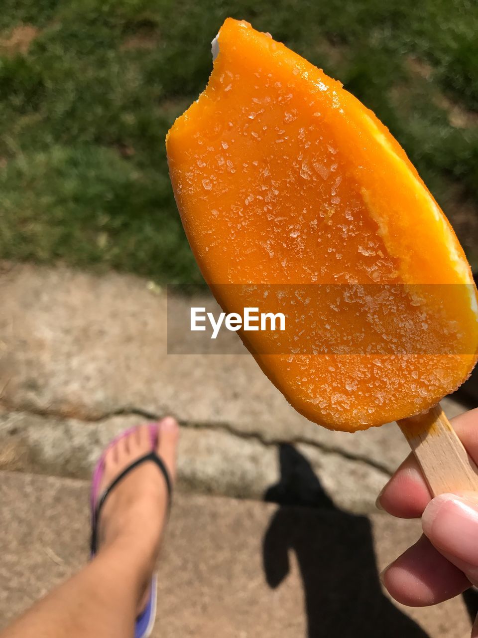 LOW SECTION OF MAN HOLDING ORANGE