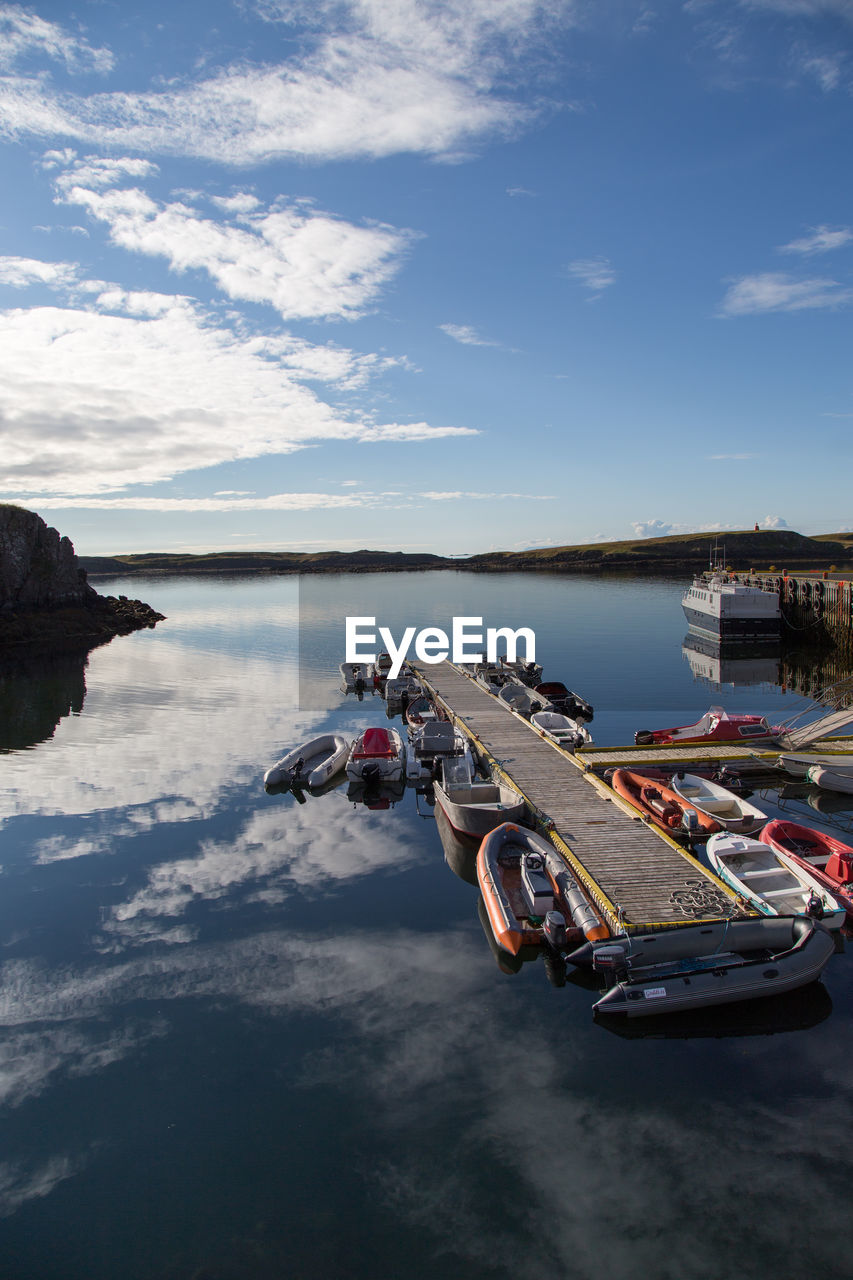 Boats moored on lake against sky