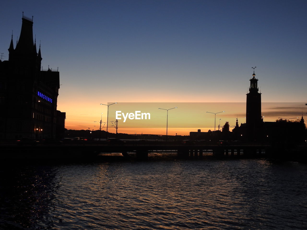 SILHOUETTE OF BUILDINGS AT WATERFRONT