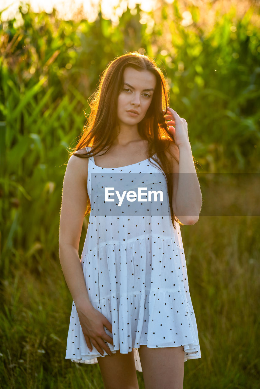 women, long hair, hairstyle, one person, young adult, yellow, plant, adult, nature, summer, fashion, standing, dress, portrait, three quarter length, grass, clothing, smiling, happiness, brown hair, front view, emotion, casual clothing, land, redhead, beauty in nature, sunlight, green, child, outdoors, leisure activity, tree, photo shoot, teenager, looking at camera, looking, lifestyles, field, relaxation, day, meadow, portrait photography, rural scene, contemplation, landscape, sundress, focus on foreground, tranquility, blond hair, spring, plain, springtime, carefree, person, back lit, childhood, female, sunset, pattern, environment, sky, cheerful, forest, positive emotion, enjoyment