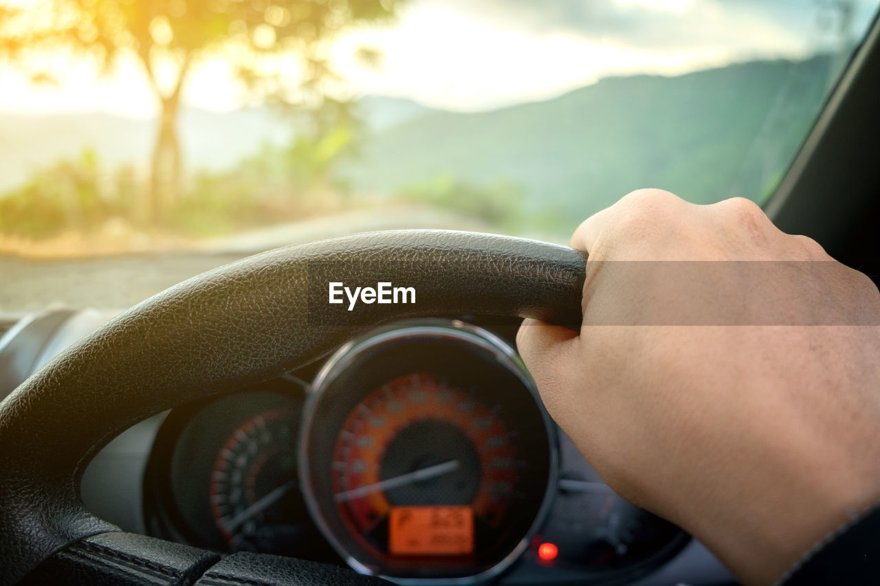 Cropped hand of man driving car