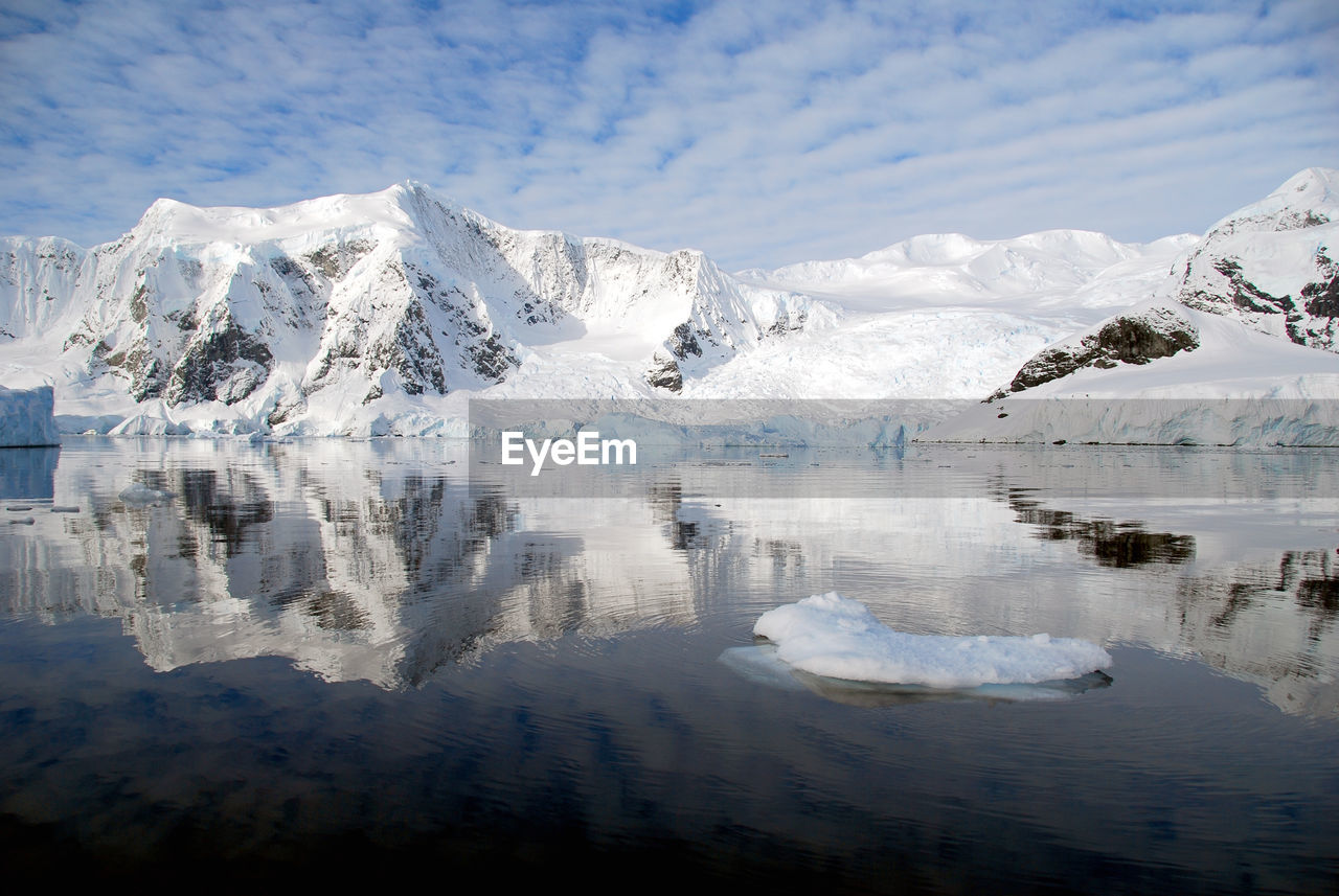 Scenic view of lake by glacier against sky