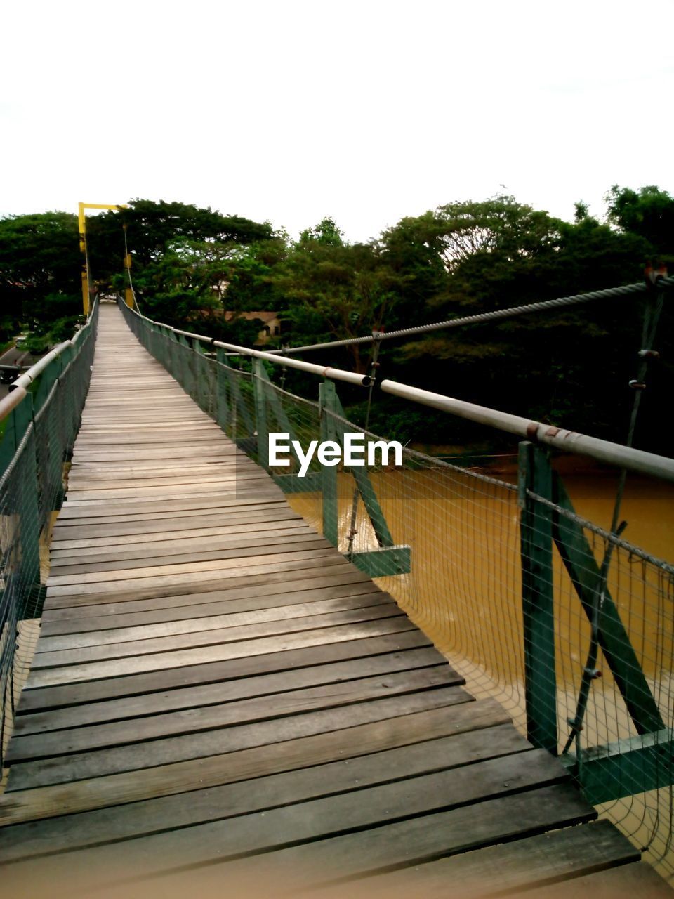 FOOTBRIDGE ON LANDSCAPE AGAINST SKY