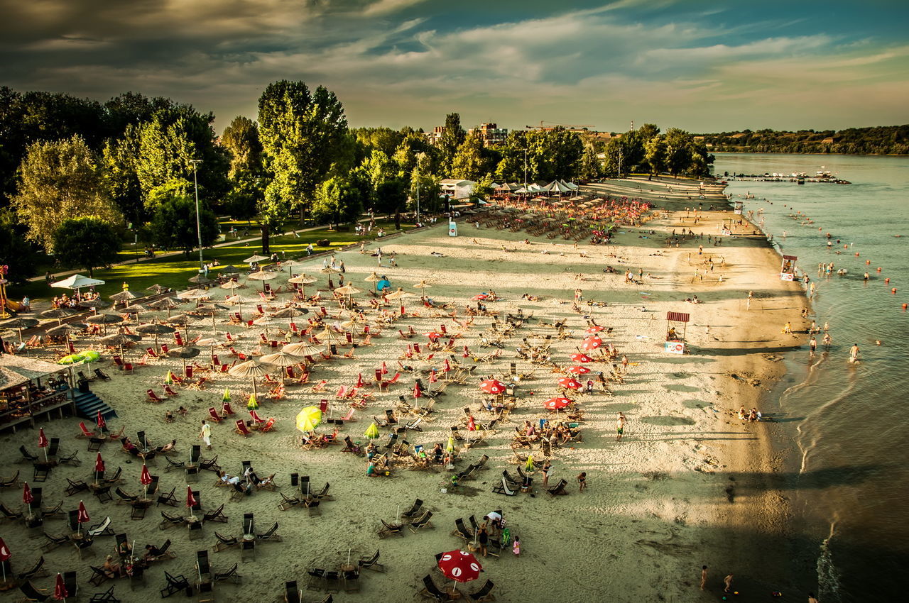 HIGH ANGLE VIEW OF PEOPLE AT SHORE AGAINST SKY