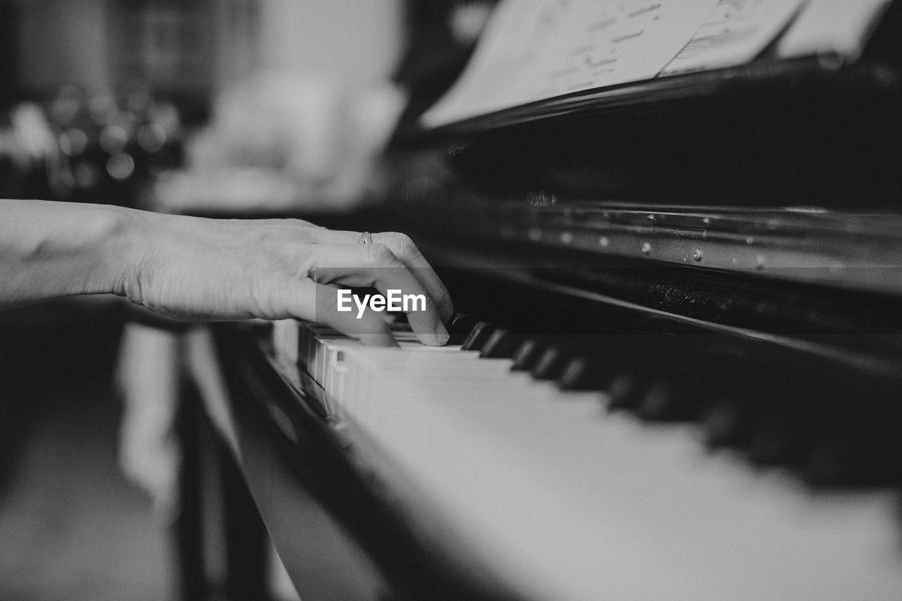 CLOSE-UP OF HUMAN HAND PLAYING PIANO