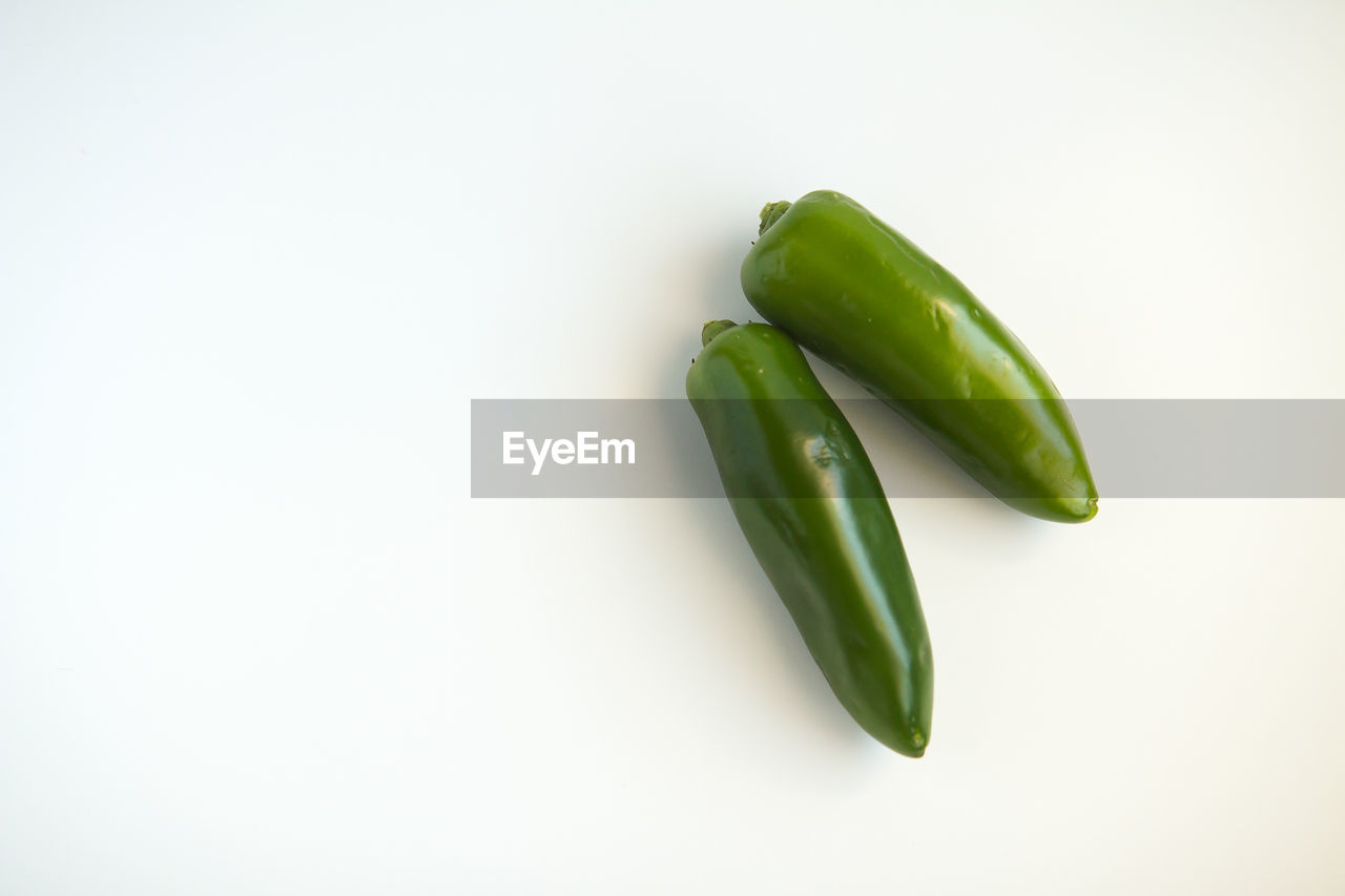 Close-up of green jalapeno peppers on white background