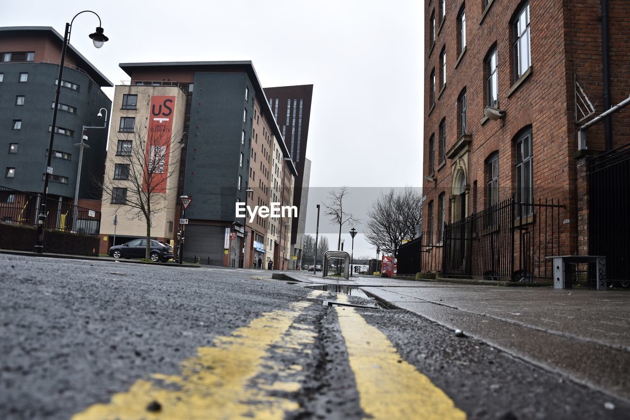 STREET AMIDST BUILDINGS AGAINST SKY